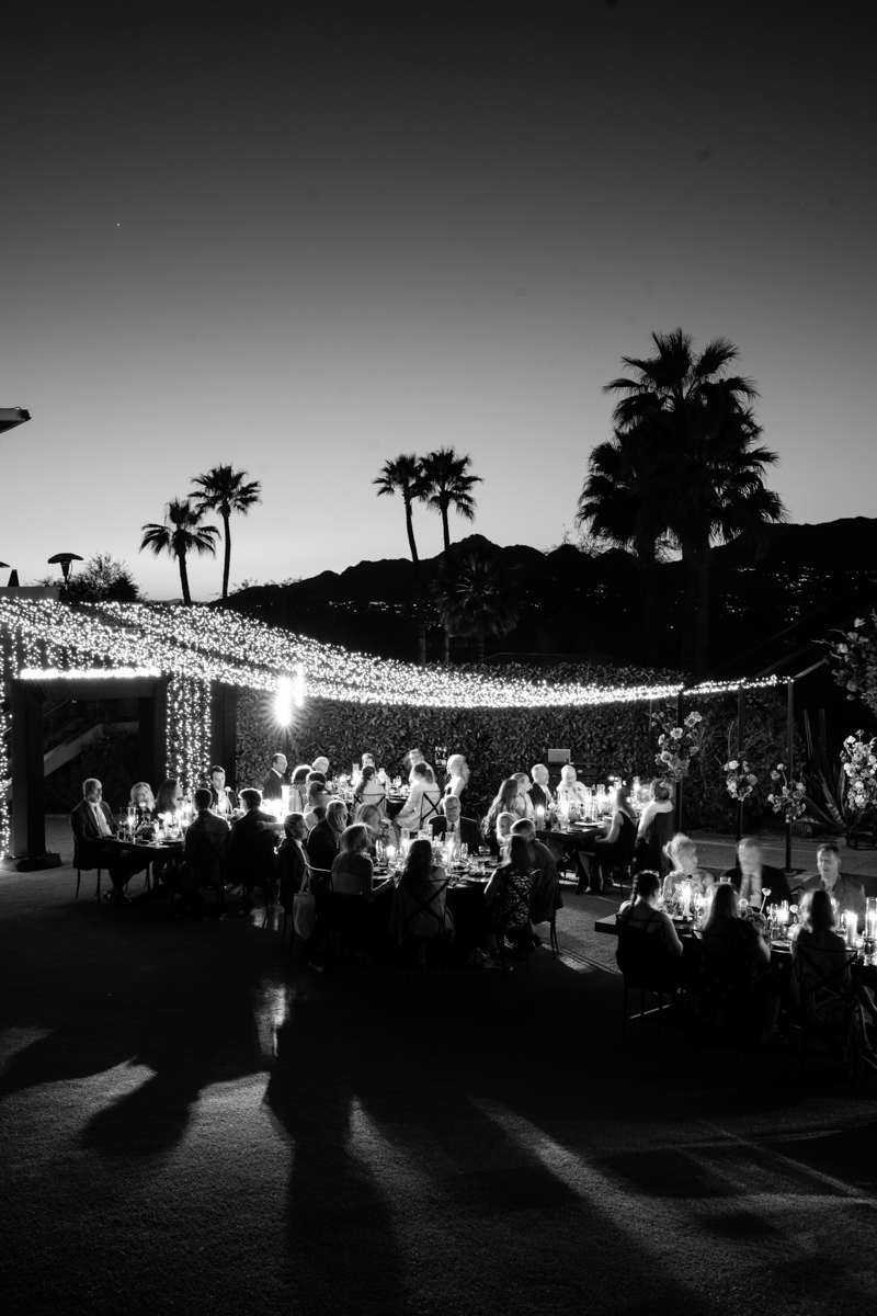 black tent structure with twinkle lights and colorful florals