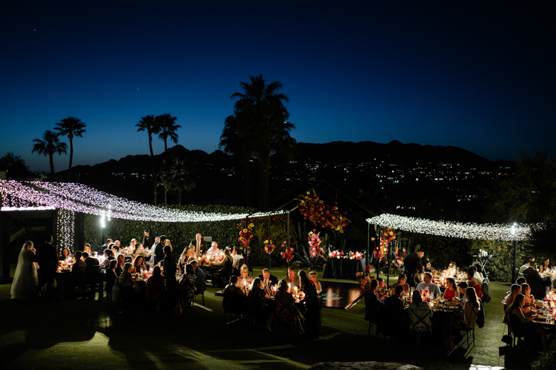 black tent structure with twinkle lights and colorful florals